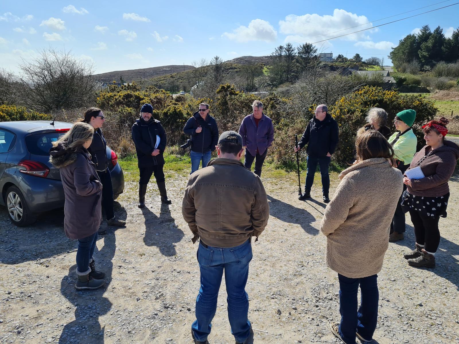 A group of people stood outdoors in a ring